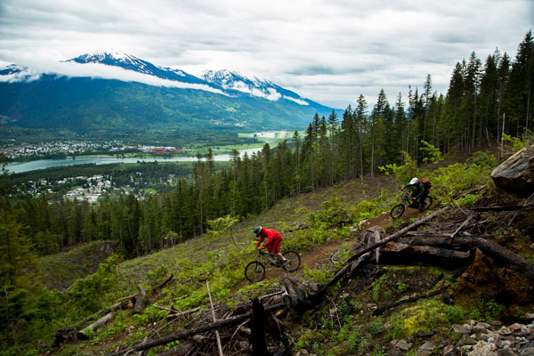 Riders on a downhill trail overlooking Revelstoke